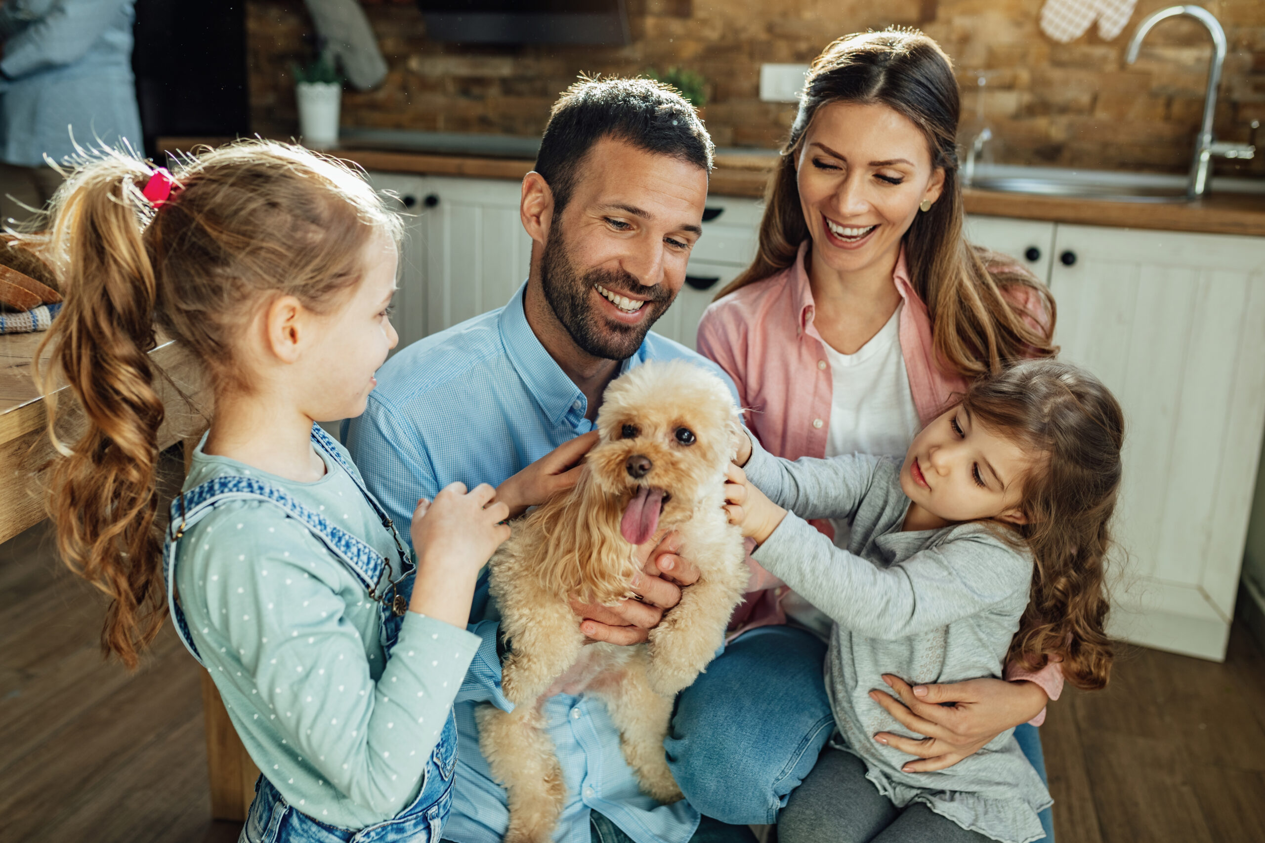 Young Happy Family Having Fun With Their Dog at Home
